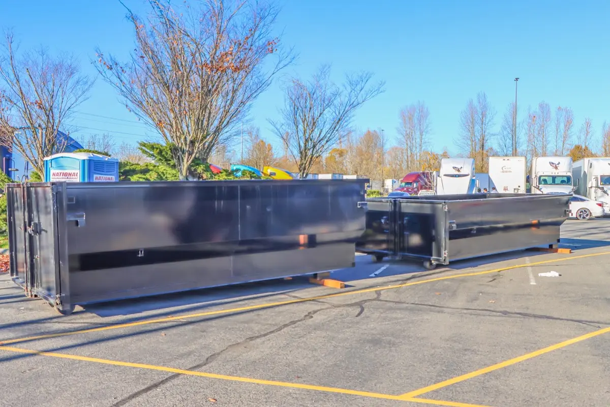 Professional dumpster rental service with roll-off container on residential driveway in Bear Creek